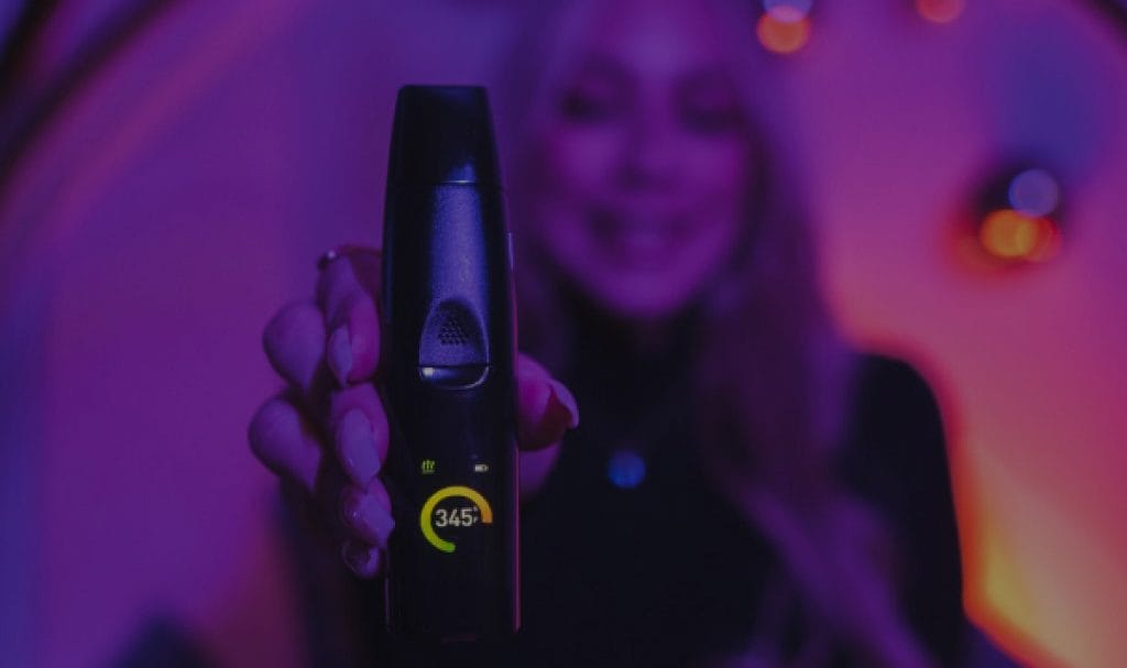 A woman holds a vape to camera