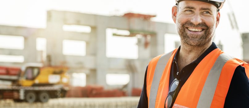 A construction worker in front of a construction site