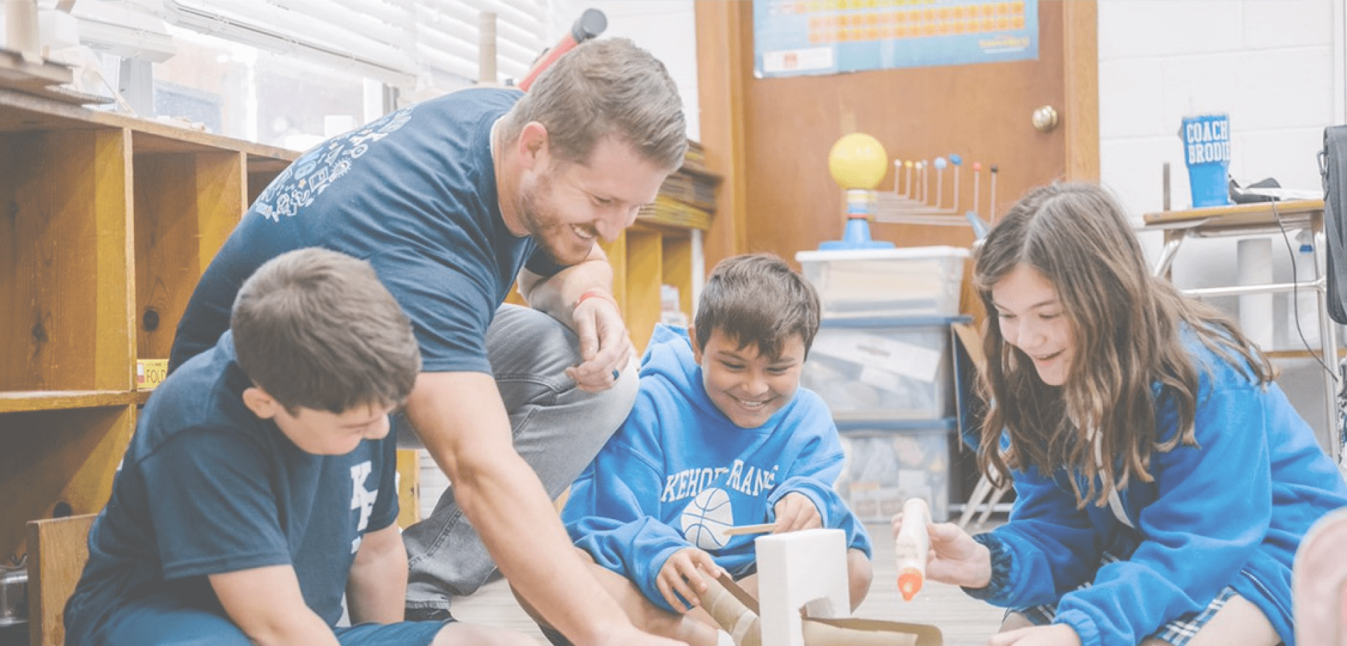 Children talk with their teacher in school